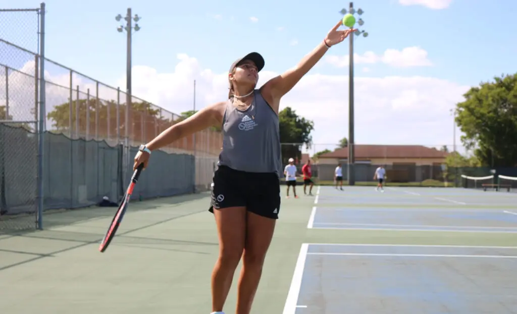 FNU tennis player Vanessa Simone mid serve.