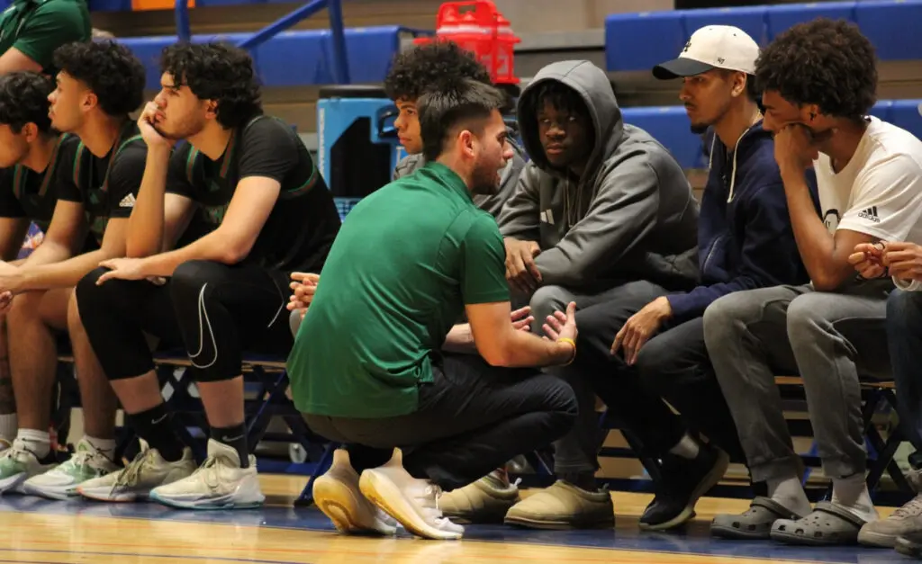 Daniel Pressman coaching on bench at Florida Memorial University.