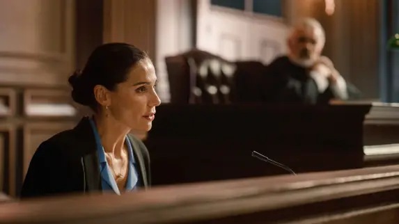 header image of lawyer sitting next to judge as witness in court