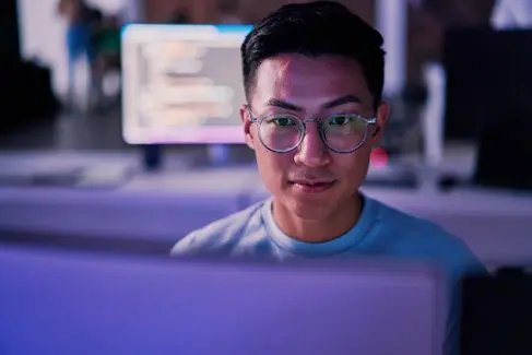 image of business analyst sitting behind computer facing the camera