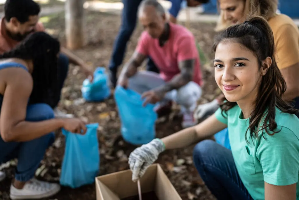 Smiling volunteer participating in a community cleanup effort, demonstrating leadership, teamwork, and social responsibility at Florida National University