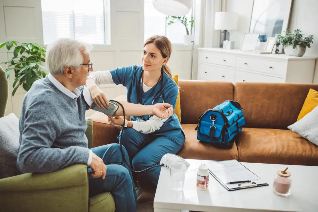 Patient care technician taking patient's blood pressure.