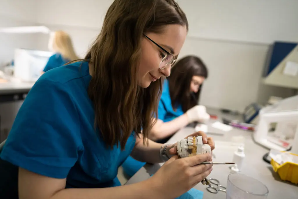 dental lab technician working on dental cast