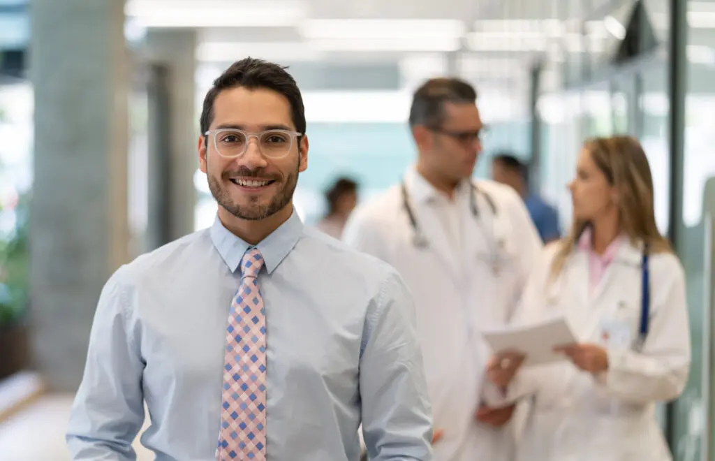 healthcare manager standing in hospital in front of doctor and nurse