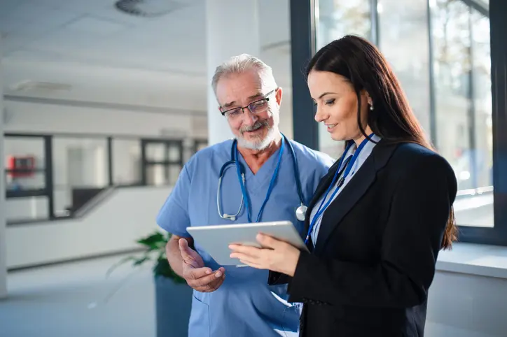 health services administrator talking to doctor in hospital