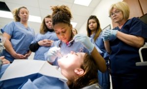dental assistant examining patient's mouth