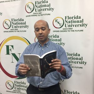 FNU Grad and Author Anibal poses while holding his book