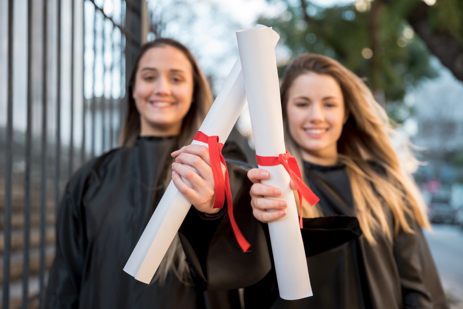 Girls at graduation showing their certificates.