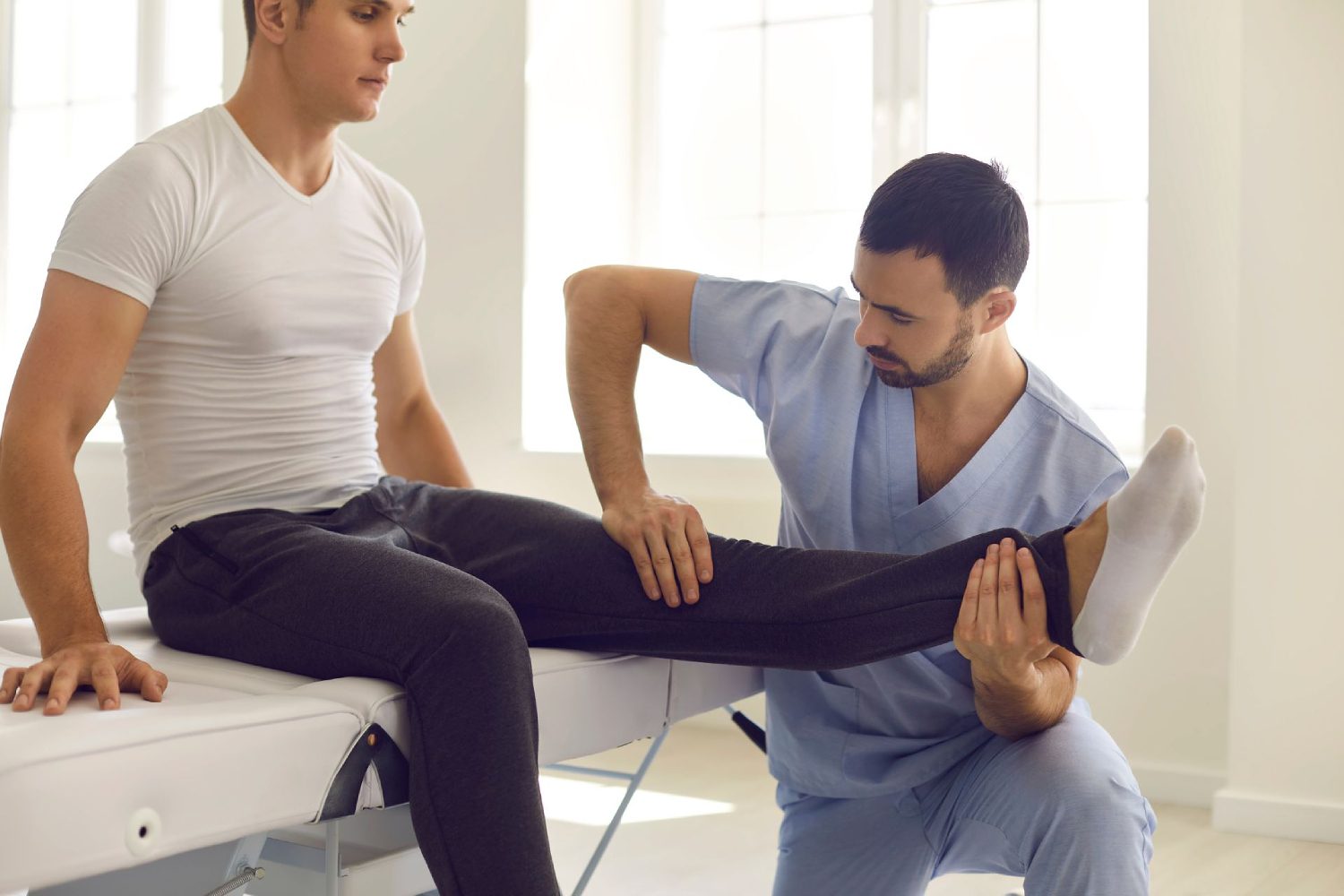 Photograph featuring a male physical therapist assistant working closely with a client during a therapy session. The image reflects the supportive and professional relationship between the assistant and the client as they engage in exercises or discuss treatment plans. This visual emphasizes the compassionate and client-centered approach of male physical therapist assistants in helping individuals achieve their physical health goals.