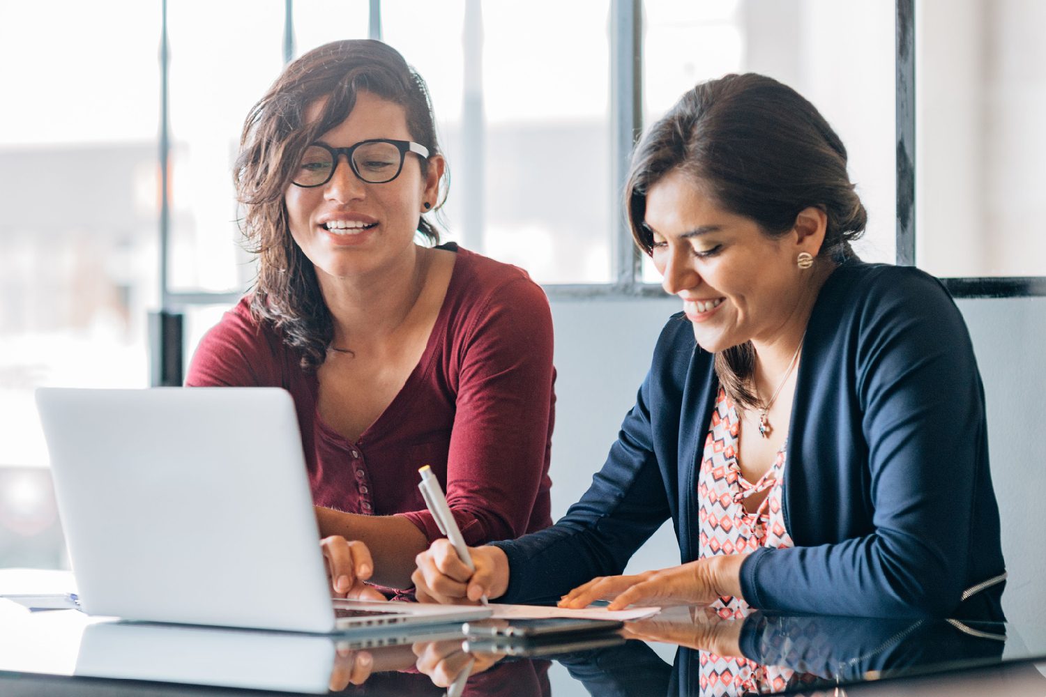 Collaborative scene featuring two accomplished women in the field of Industrial and Organizational Psychology, engaged in a purposeful discussion within their contemporary office setting. Radiating competence, they analyze data charts and psychological models, emphasizing teamwork, diversity, and the impactful role of women in shaping organizational dynamics. The image exudes a sense of professional synergy and gender diversity in the realm of psychological research and workplace optimization.