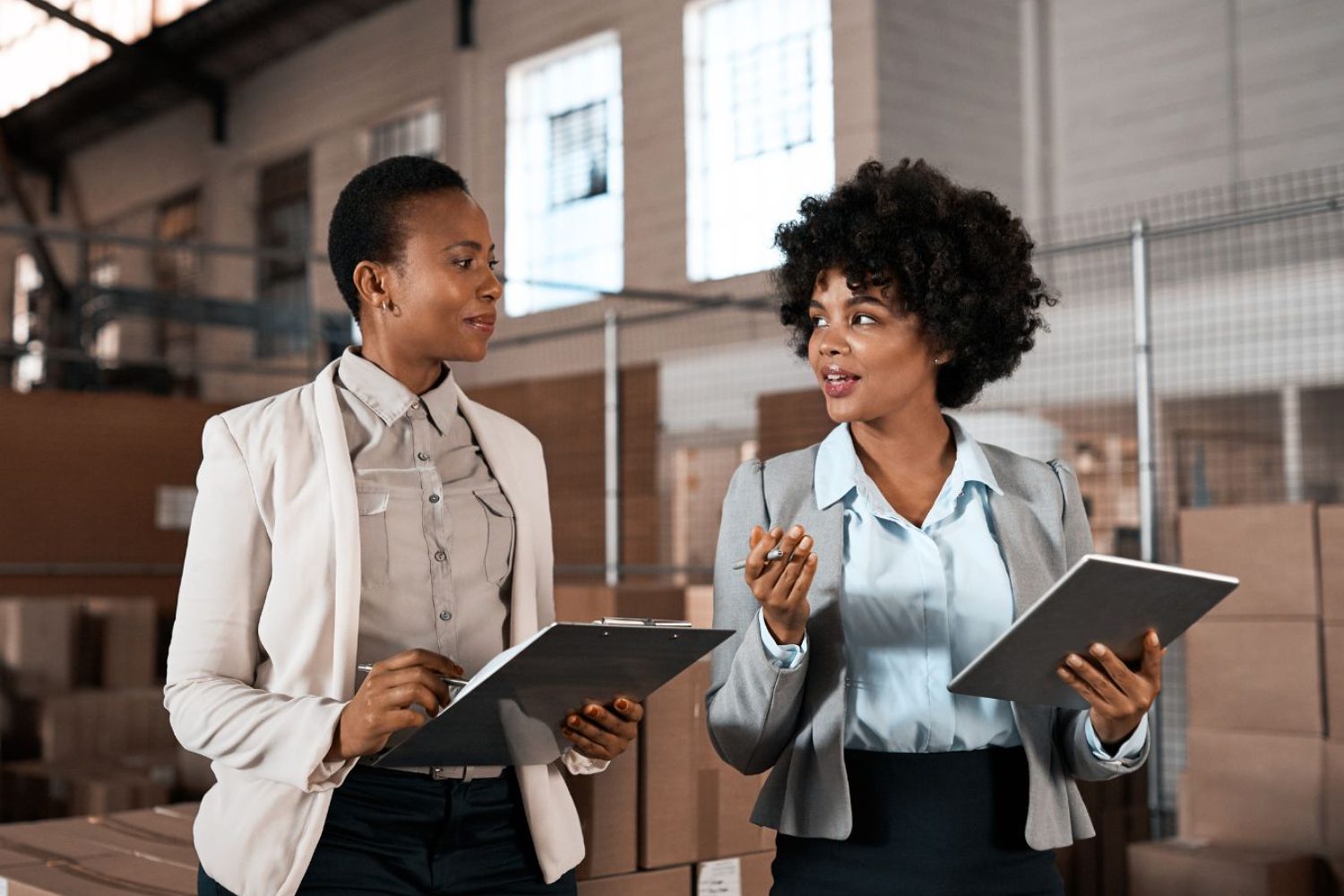 Professional women working in a repository, engaged in Operations Research analysis and strategic decision-making.