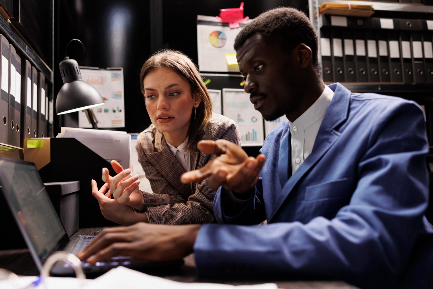 Free photo diverse businesspeople working overhours at accountancy report, analyzing administrative documents in storage room. depository employees reading bureaucracy record, organizing corporate files