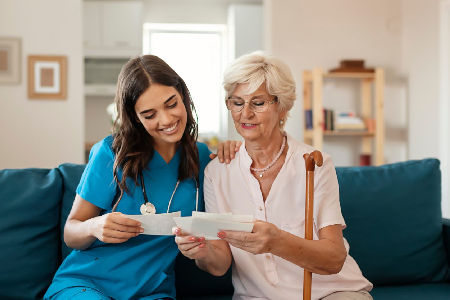 A medical professional and an elderly woman holding papers and reading them